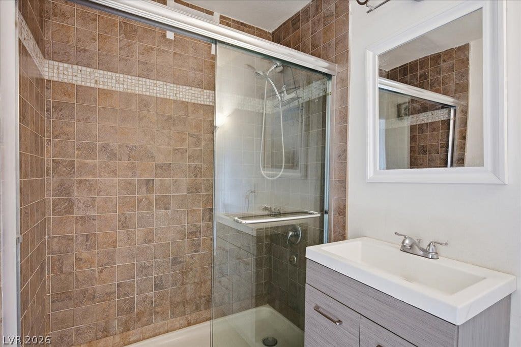 3726 Hazelwood Street, #14, Las Vegas, NV 89119 Tiled walls frame the glass-enclosed shower next to a modern vanity conveniently located as an ensuite to the primary bedroom.