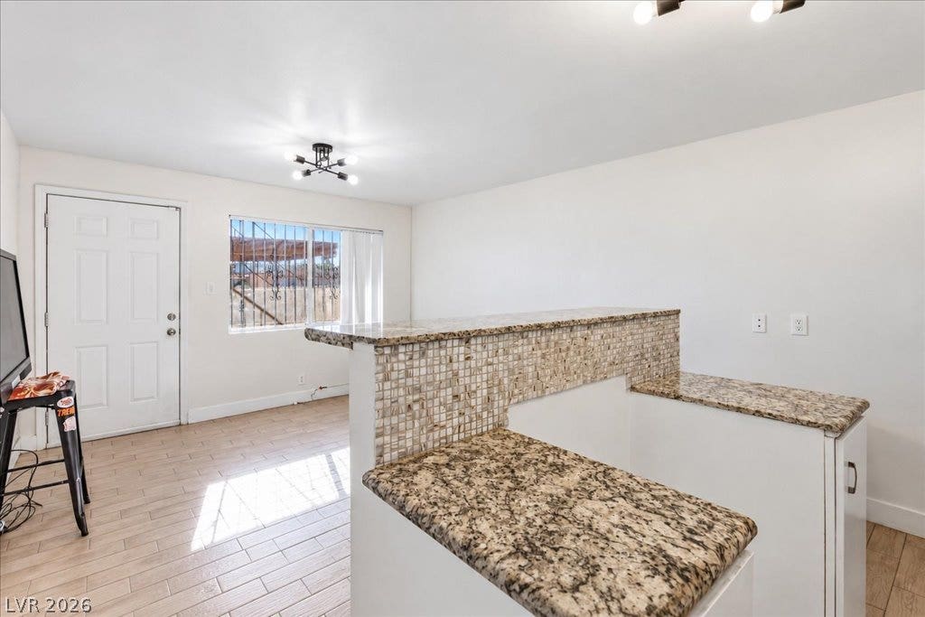 3726 Hazelwood Street, #14, Las Vegas, NV 89119 Gleaming granite countertops elevate this open living area with wood-look tile flooring. Kitchen island has a space for a new electric stove
