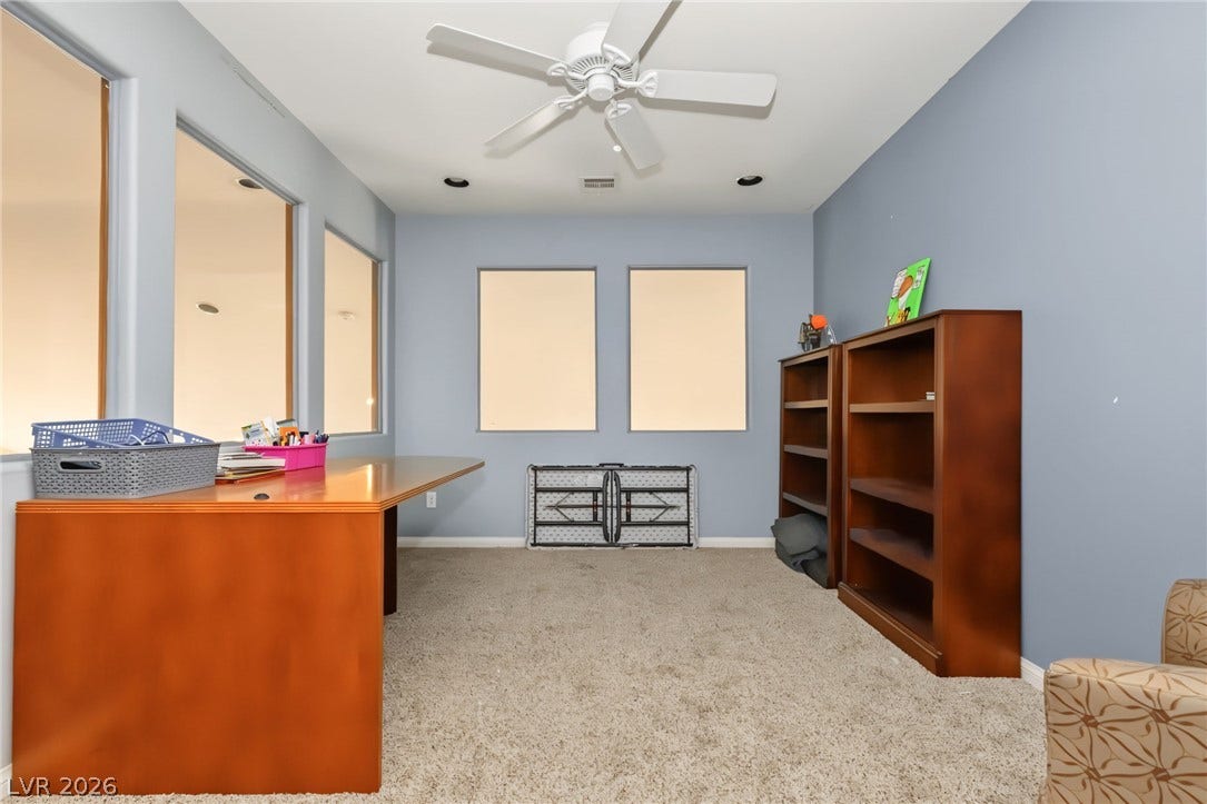 7021 Albatross Attic Street, North Las Vegas, NV 89084 A quiet home office features wall-to-wall carpeting and interior windows looking out to the hallway.