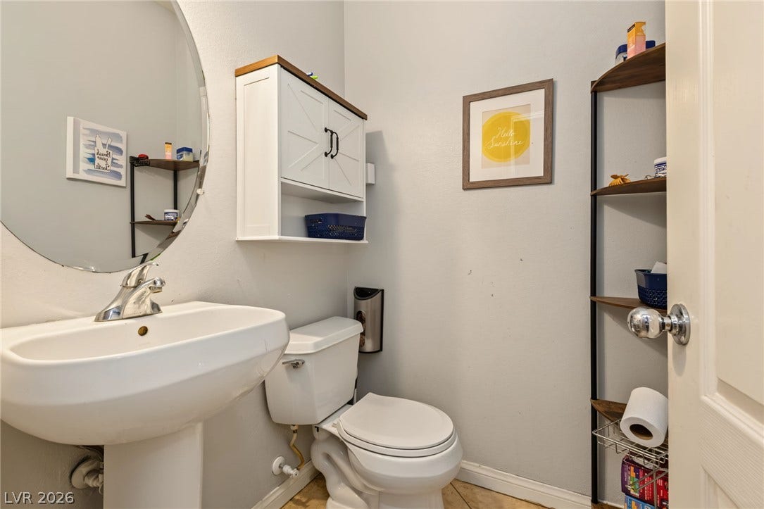 7021 Albatross Attic Street, North Las Vegas, NV 89084 A classic pedestal sink paired with neutral tile flooring defines this functional powder room.