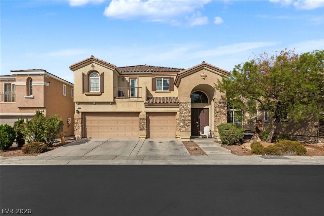 7021 Albatross Attic Street, North Las Vegas, NV 89084 An inviting exterior displays stone accents, a multi-car garage, and a Spanish-style tiled roof.