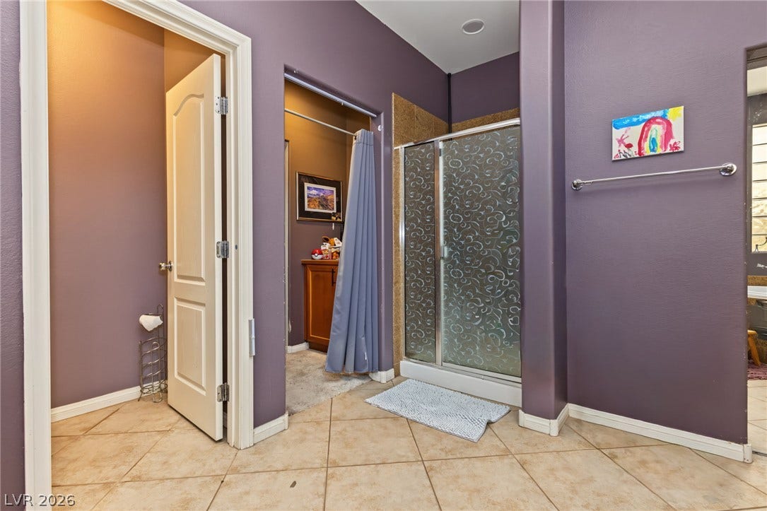 7021 Albatross Attic Street, North Las Vegas, NV 89084 Tiled flooring and a walk-in shower anchor this functional bathroom layout.