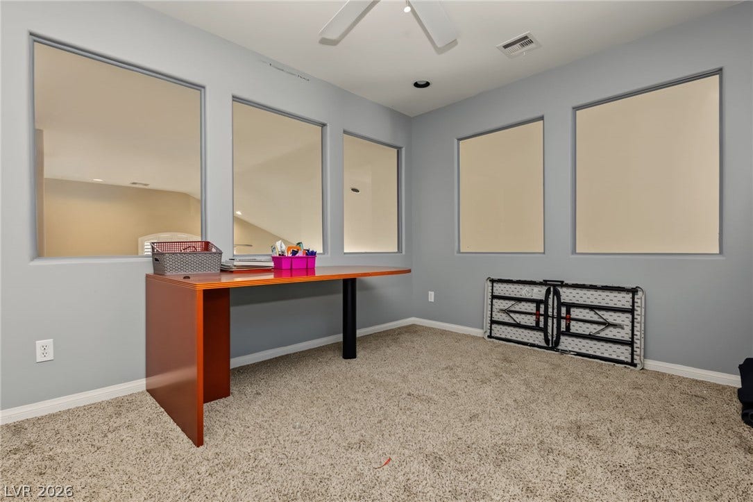 7021 Albatross Attic Street, North Las Vegas, NV 89084 Thick wall openings connect this carpeted office space to the surrounding interior areas.