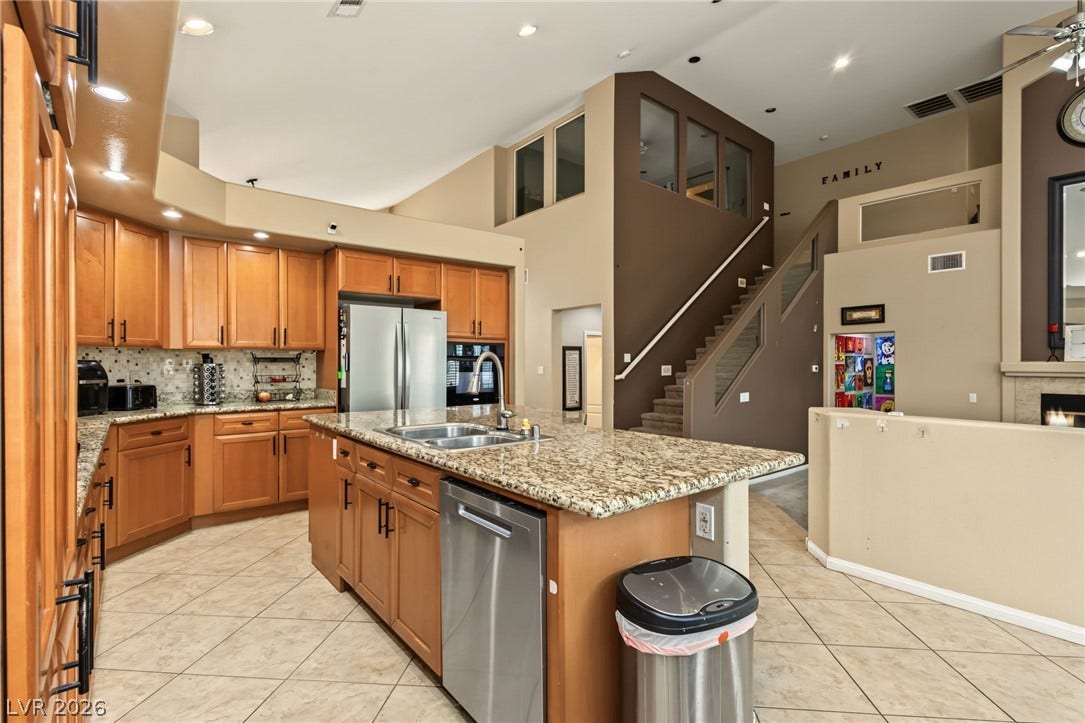 7021 Albatross Attic Street, North Las Vegas, NV 89084 An open kitchen area showcases polished granite countertops, warm wood cabinetry, and tiled flooring.