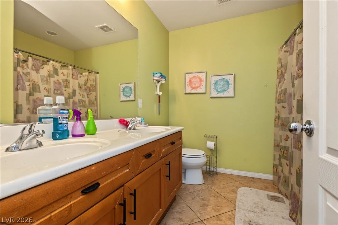 7021 Albatross Attic Street, North Las Vegas, NV 89084 A spacious double vanity and tile flooring define this functional secondary bathroom.
