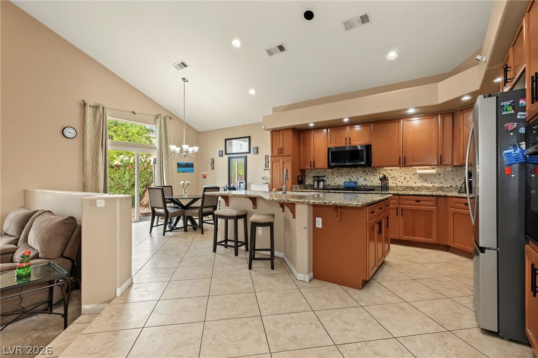 7021 Albatross Attic Street, North Las Vegas, NV 89084 An open kitchen layout flows seamlessly into a dining area beneath high vaulted ceilings.