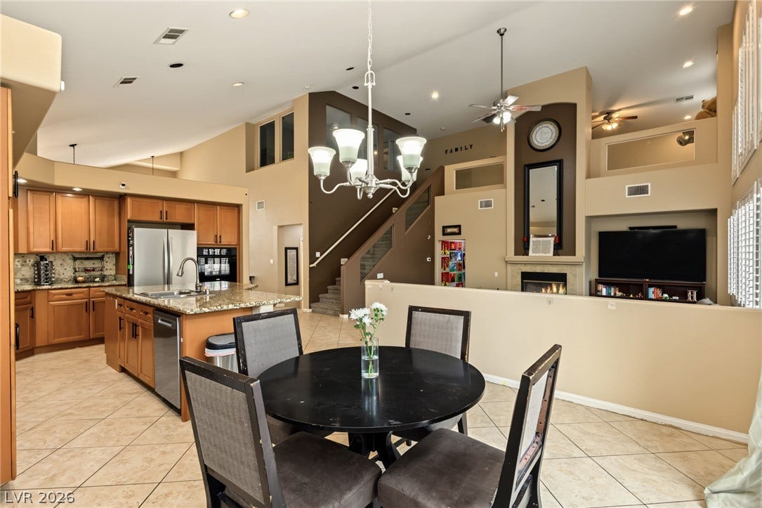 7021 Albatross Attic Street, North Las Vegas, NV 89084 An open floor plan connects the kitchen, dining, and living areas beneath high vaulted ceilings.