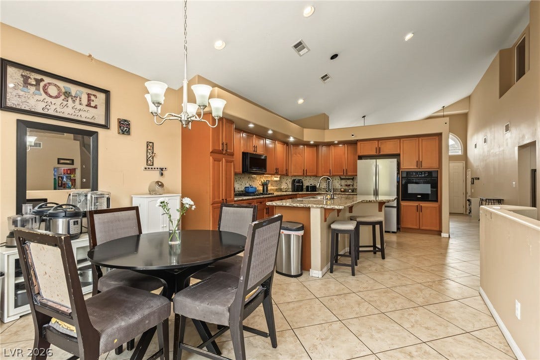7021 Albatross Attic Street, North Las Vegas, NV 89084 A spacious kitchen with classic wooden cabinetry and tiled flooring flows into the dining area.