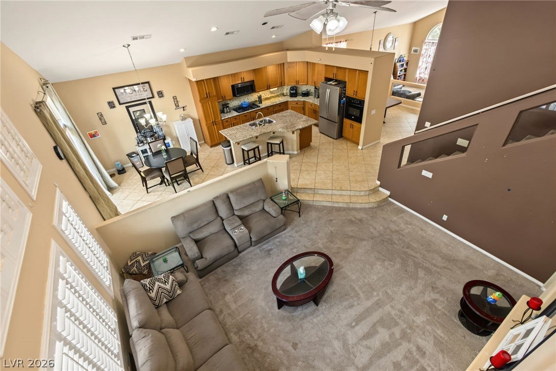 7021 Albatross Attic Street, North Las Vegas, NV 89084 An open multi-level layout connects the carpeted living area to a spacious kitchen.
