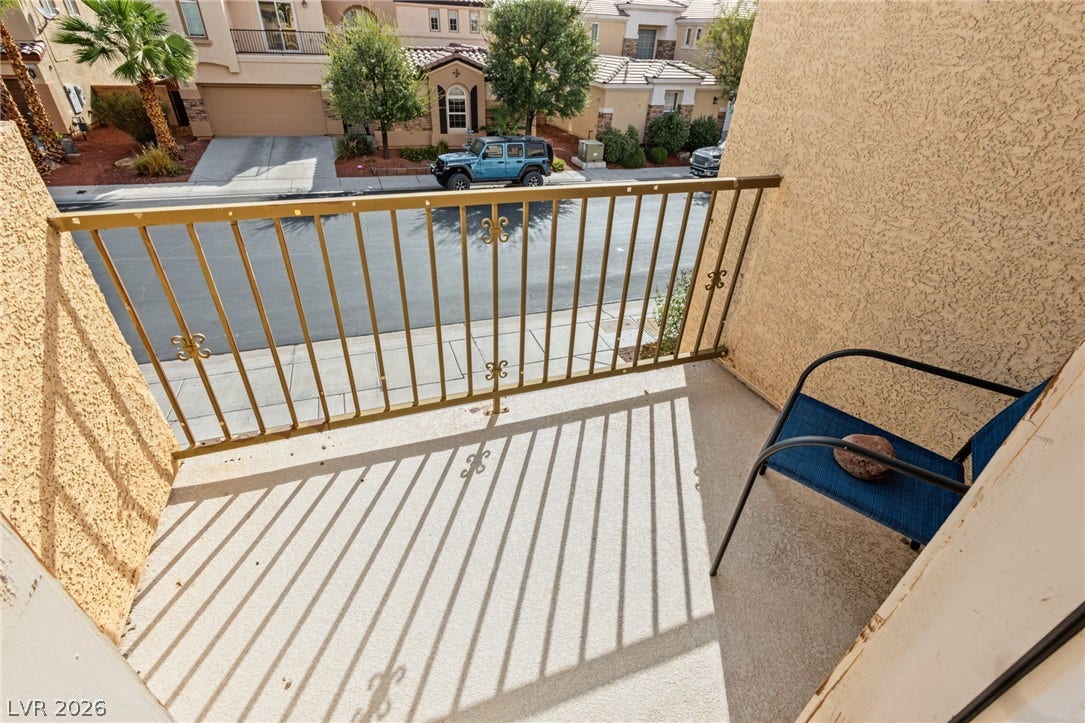 7021 Albatross Attic Street, North Las Vegas, NV 89084 Private outdoor balcony features stucco walls, concrete flooring, and metal railings overlooking the neighborhood.
