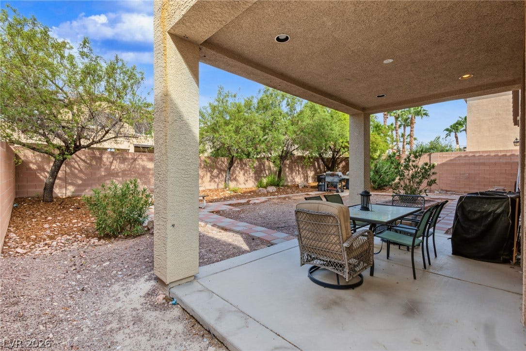 7021 Albatross Attic Street, North Las Vegas, NV 89084 A sheltered concrete patio overlooks a fenced backyard with desert landscaping.