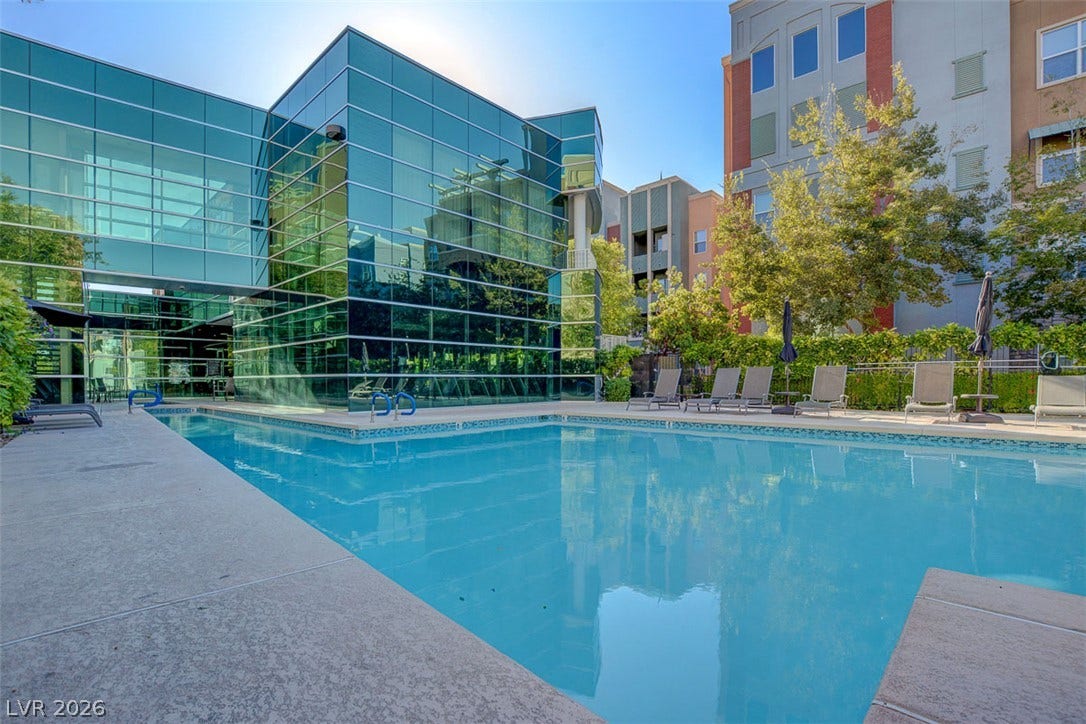 32 E Serene Avenue, #407, Las Vegas, NV 89123 Sleek glass architecture reflects over the sparkling pool and concrete lounging deck.