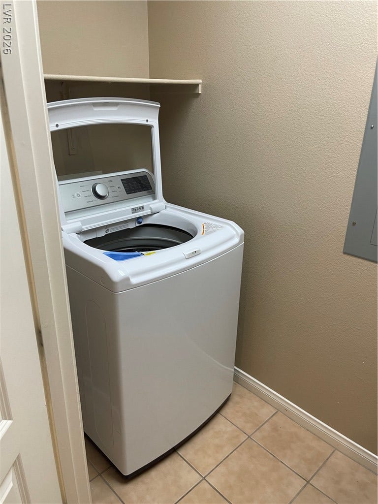 32 E Serene Avenue, #407, Las Vegas, NV 89123 Tiled flooring and neutral walls define this functional laundry closet setup.