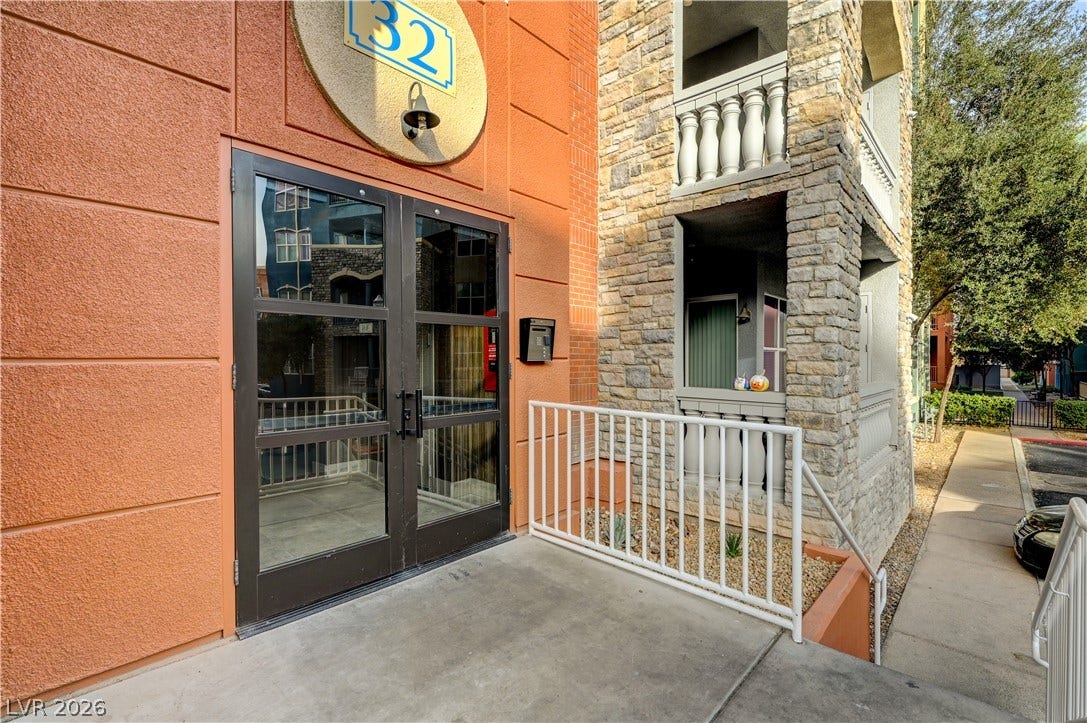 32 E Serene Avenue, #407, Las Vegas, NV 89123 A secure, modern building entry features clean concrete paths alongside elegant stone cladding.