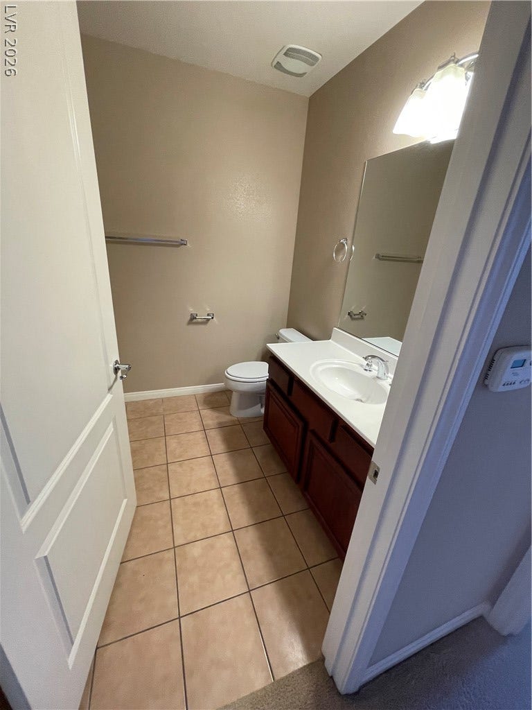 32 E Serene Avenue, #407, Las Vegas, NV 89123 Warm tile flooring and a dark wood vanity anchor this practical half bath space.