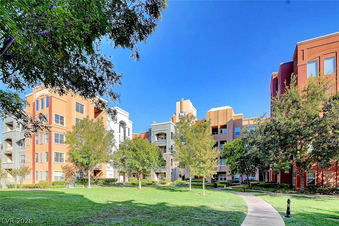 32 E Serene Avenue, #407, Las Vegas, NV 89123 Mature trees frame the paved walkway winding through a manicured central courtyard.