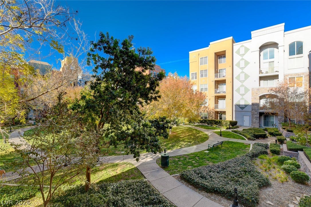 32 E Serene Avenue, #407, Las Vegas, NV 89123 Paved pathways wind through a landscaped courtyard area adjacent to the residential building.