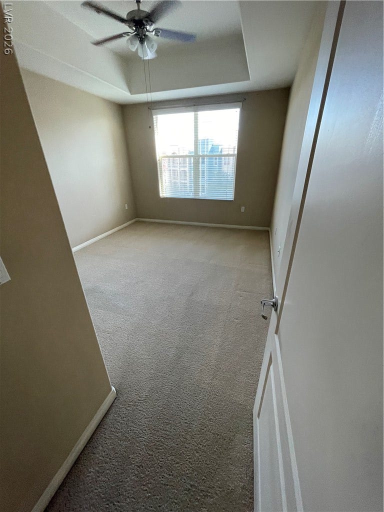 32 E Serene Avenue, #407, Las Vegas, NV 89123 Soft carpeting pairs with a large window in this high-ceilinged room.