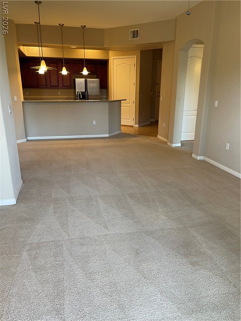 32 E Serene Avenue, #407, Las Vegas, NV 89123 Plush carpeting meets an open-concept layout leading directly into the kitchen.