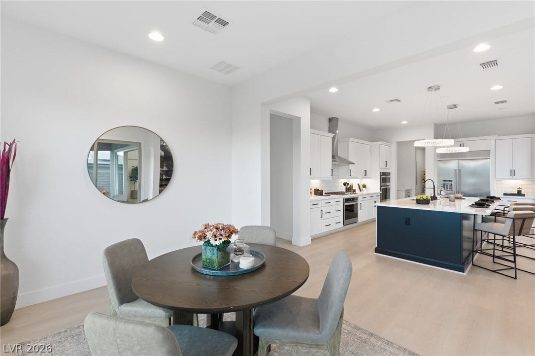 An open-concept living space integrates a casual dining area with a gourmet kitchen featuring a large island.