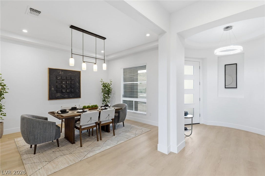 A contemporary dining room with light wood flooring provides an inviting space for gatherings.
