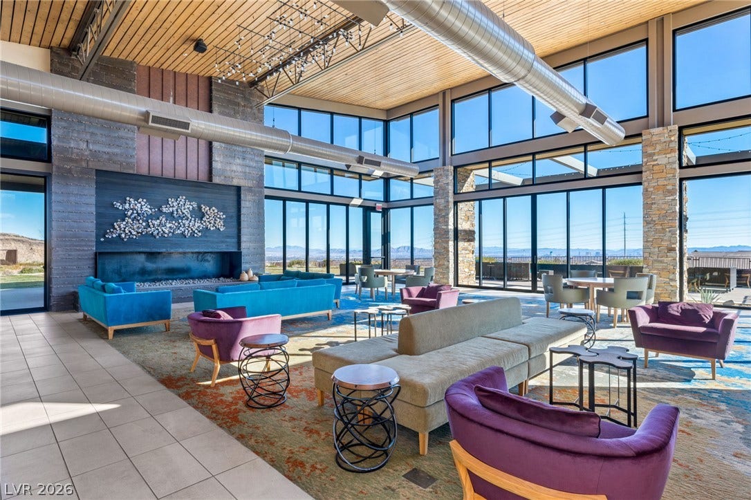 An inviting common area features a striking fireplace and walls of glass showcasing the scenic views.