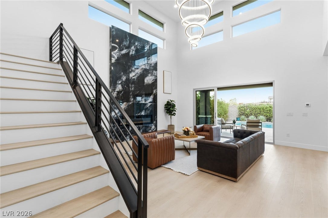 Natural light floods this living area, showcasing the statement fireplace and seamless indoor-outdoor access to the pool.