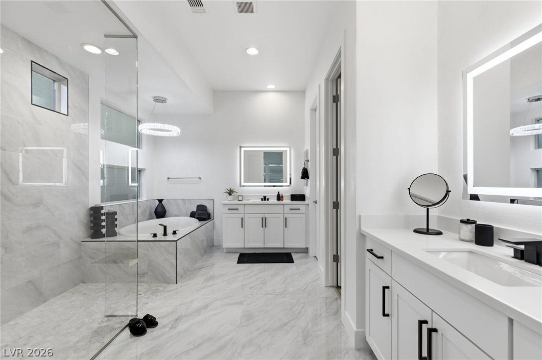 Luxurious spa-like bathroom features a deep soaking tub and a sleek, glass-enclosed shower.