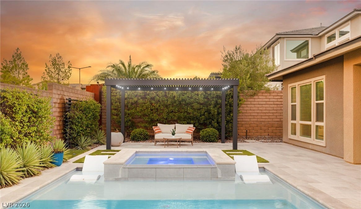 An inviting backyard oasis offers a sparkling pool, a serene spa, and a shaded pergola perfect for outdoor enjoyment.