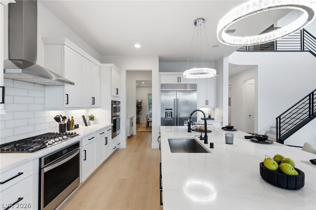 Culinary delights await in this bright kitchen with an expansive island, sleek stainless appliances, and contemporary lighting.