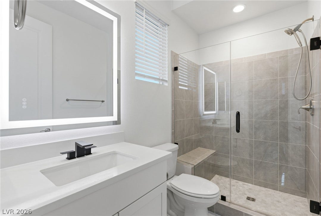 A sleek, contemporary bathroom featuring a spacious glass-enclosed shower and modern vanity.