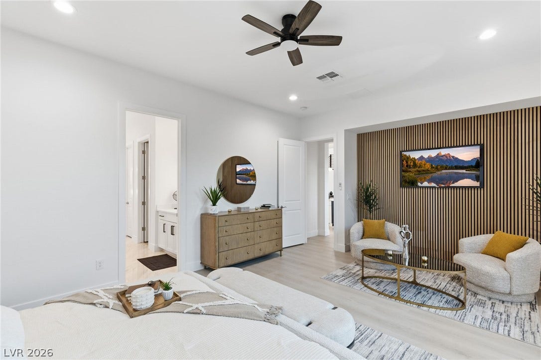 A well-appointed bedroom suite features a decorative wood-slat accent wall, a ceiling fan, and light wood flooring.