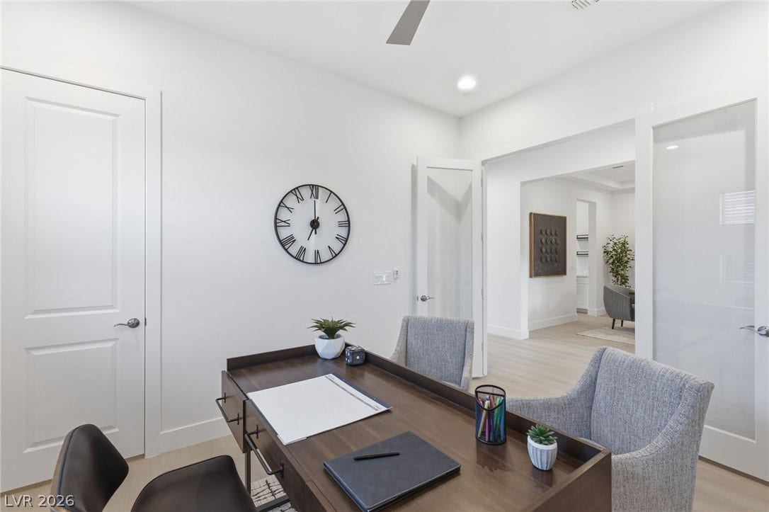 A refined home office with light wood flooring and a modern desk provides an ideal workspace.