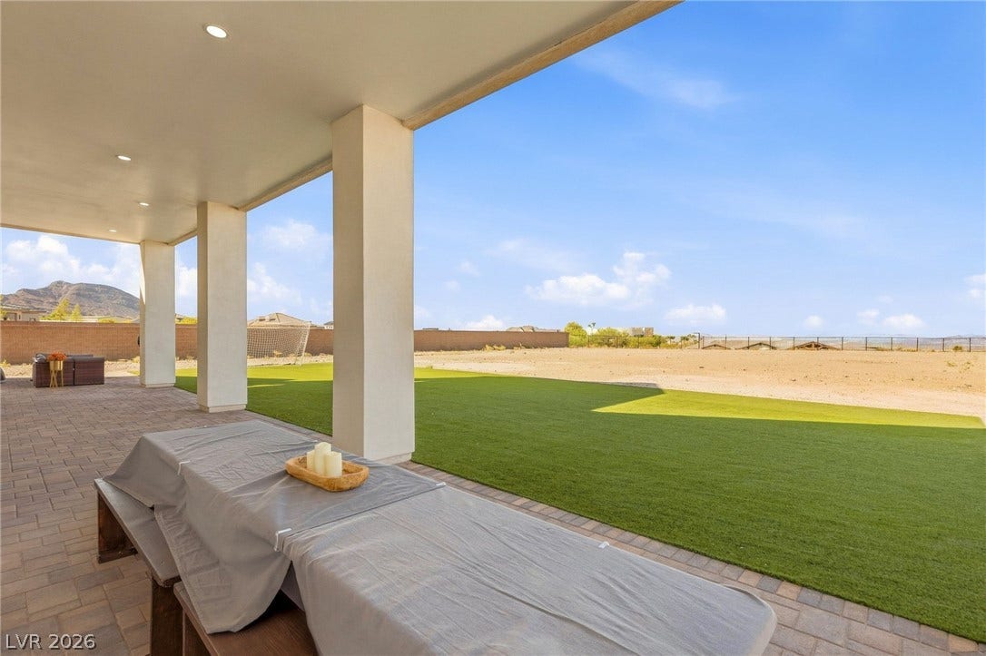 324 Wanda Road, Henderson, NV 89002 A spacious covered patio overlooks a manicured green lawn framing sweeping desert and mountain views.