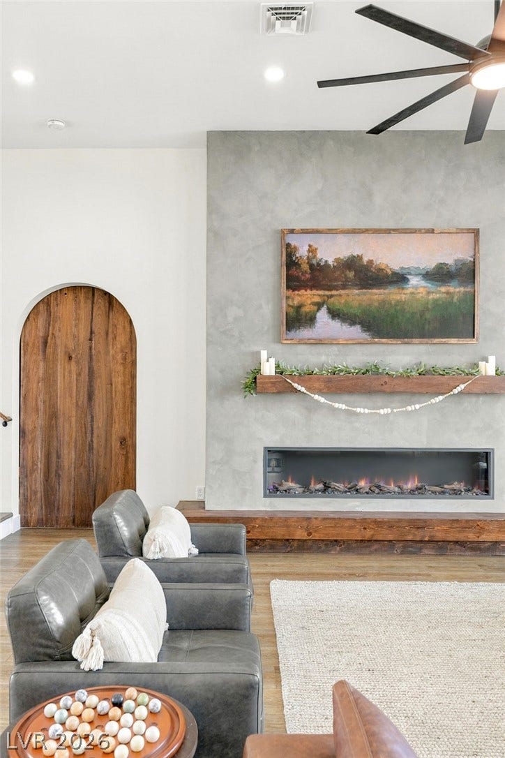 324 Wanda Road, Henderson, NV 89002 A modern fireplace acts as the focal point alongside an arched wooden doorway.