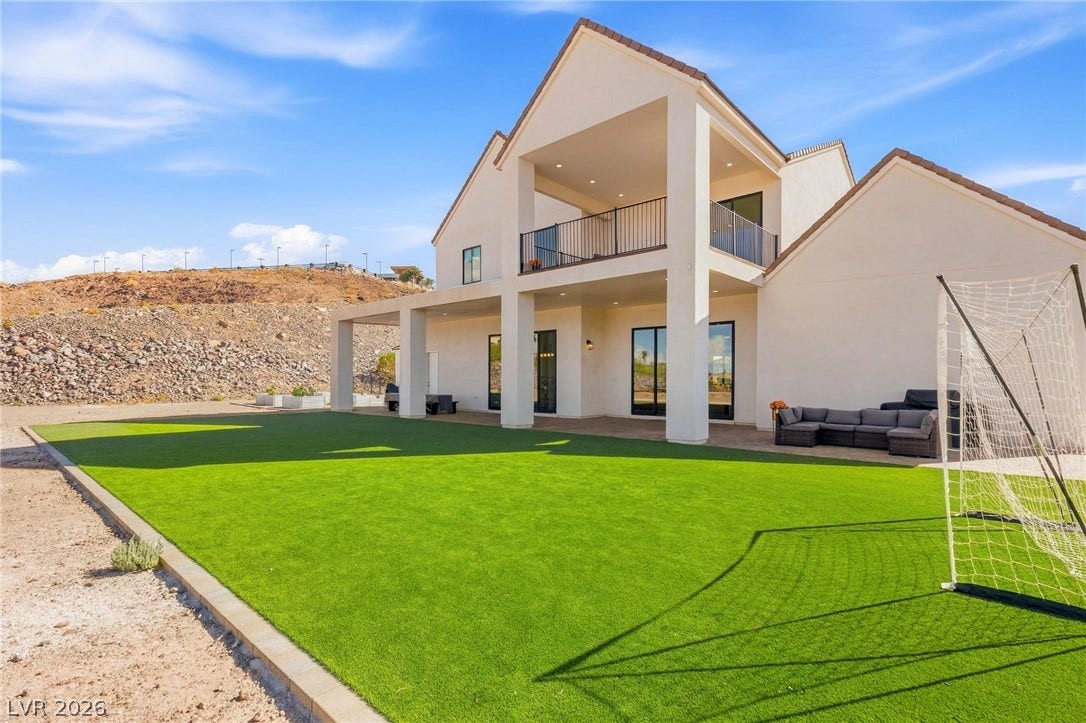 324 Wanda Road, Henderson, NV 89002 A spacious green lawn sits beside a modern two-story home with stucco siding.