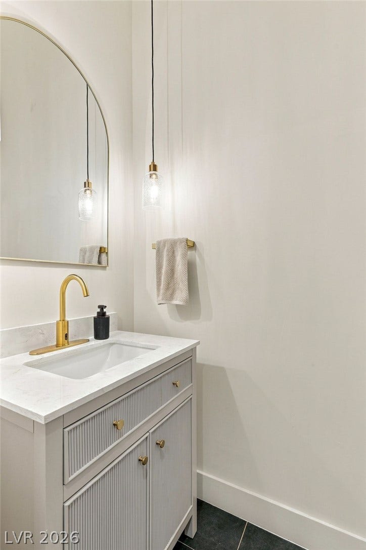 324 Wanda Road, Henderson, NV 89002 Elegant gold hardware pairs beautifully with stone counters and contemporary textured cabinetry in this washroom.