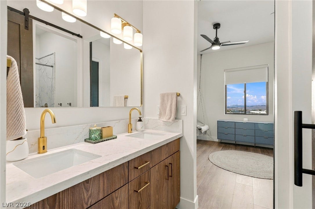 324 Wanda Road, Henderson, NV 89002 Gold fixtures accent a sleek double vanity topped with stone counters in this modern bath.