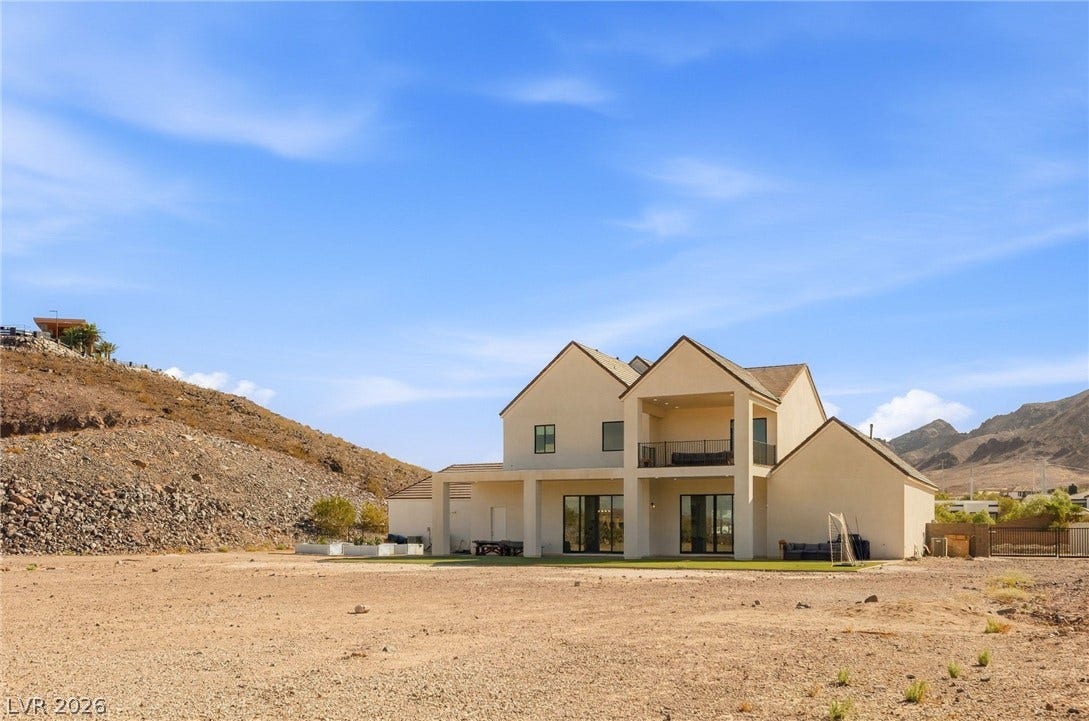 324 Wanda Road, Henderson, NV 89002 A classic stucco exterior rises against a backdrop of rugged desert mountains.