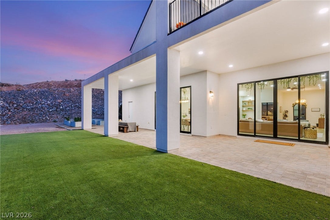 324 Wanda Road, Henderson, NV 89002 A spacious covered patio paved in stone tiles overlooks a manicured grassy lawn.