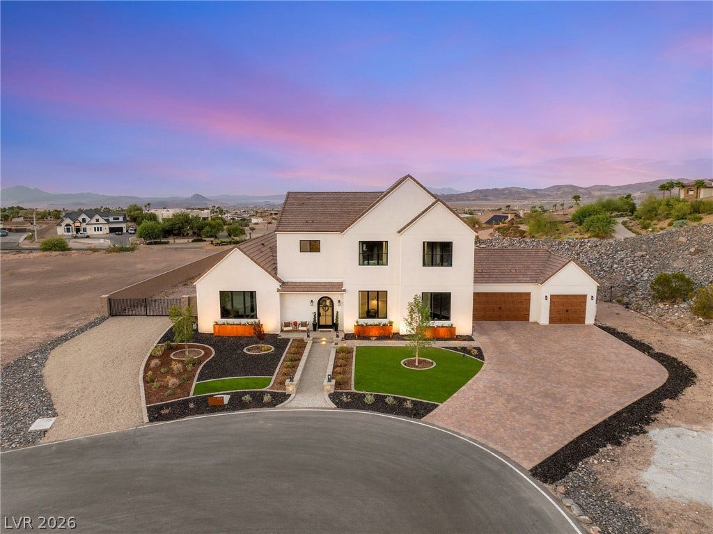 324 Wanda Road, Henderson, NV 89002 An elegant exterior showcases modern stucco walls, sleek dark windows, and a paved circular driveway.