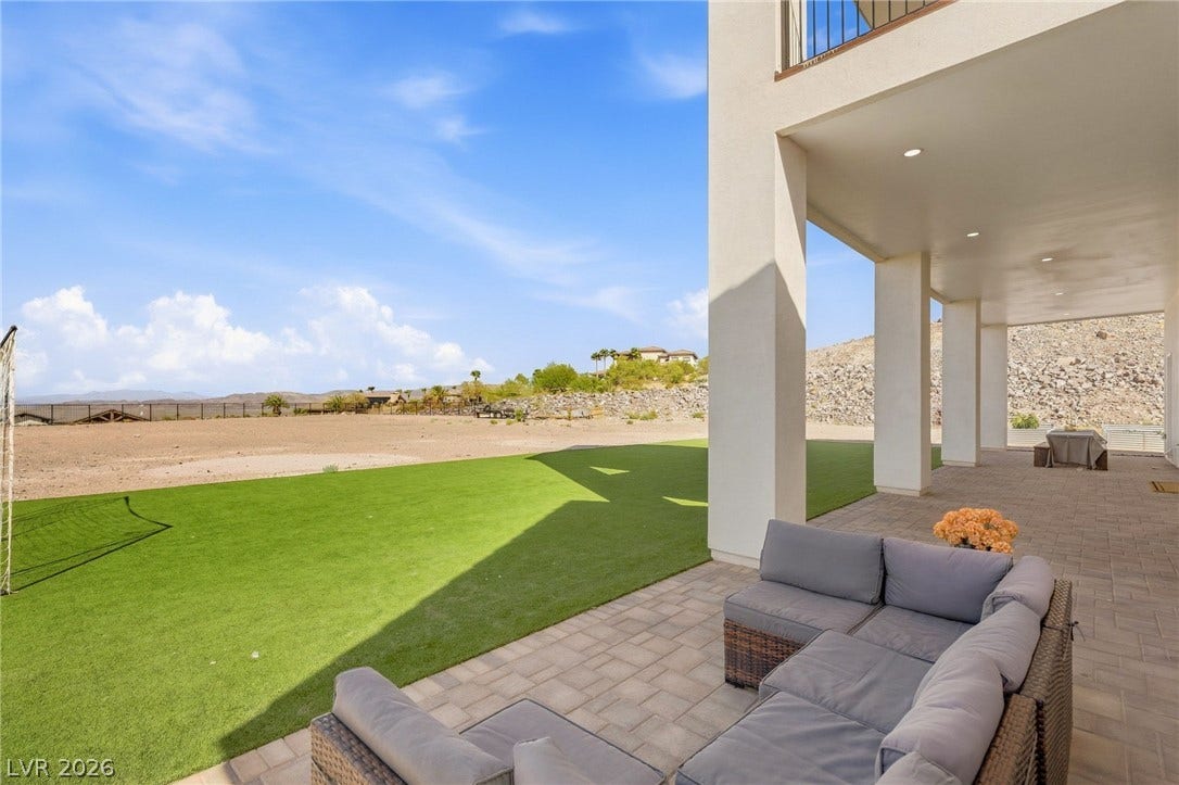 324 Wanda Road, Henderson, NV 89002 Shaded paver patios overlook a sprawling green lawn and distant mountain views.