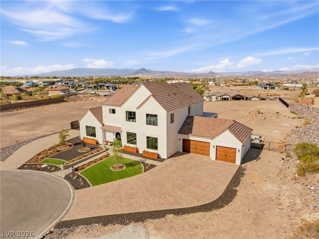 324 Wanda Road, Henderson, NV 89002 An elegant multi-level desert home features an expansive paver driveway and a tiled roof.