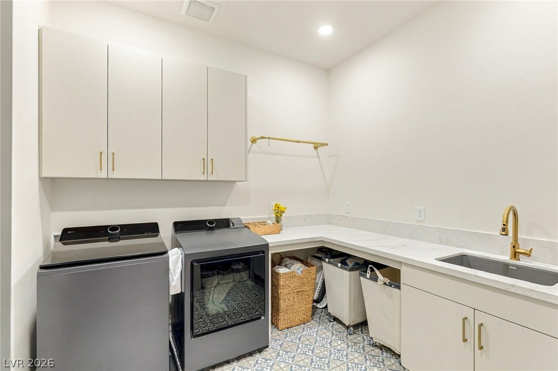 324 Wanda Road, Henderson, NV 89002 A modern utility space features patterned tile flooring, stone countertops, and extensive cabinetry.