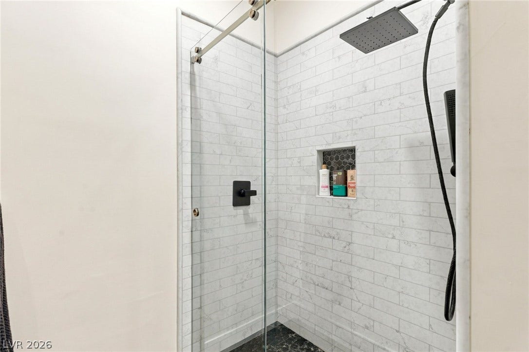 324 Wanda Road, Henderson, NV 89002 Crisp subway tile walls pair with elegant dark flooring inside this glass-enclosed walk-in shower.