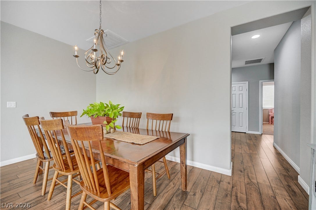 Rich wood plank flooring anchors this welcoming space, complete with wide doorways leading to adjacent rooms.
