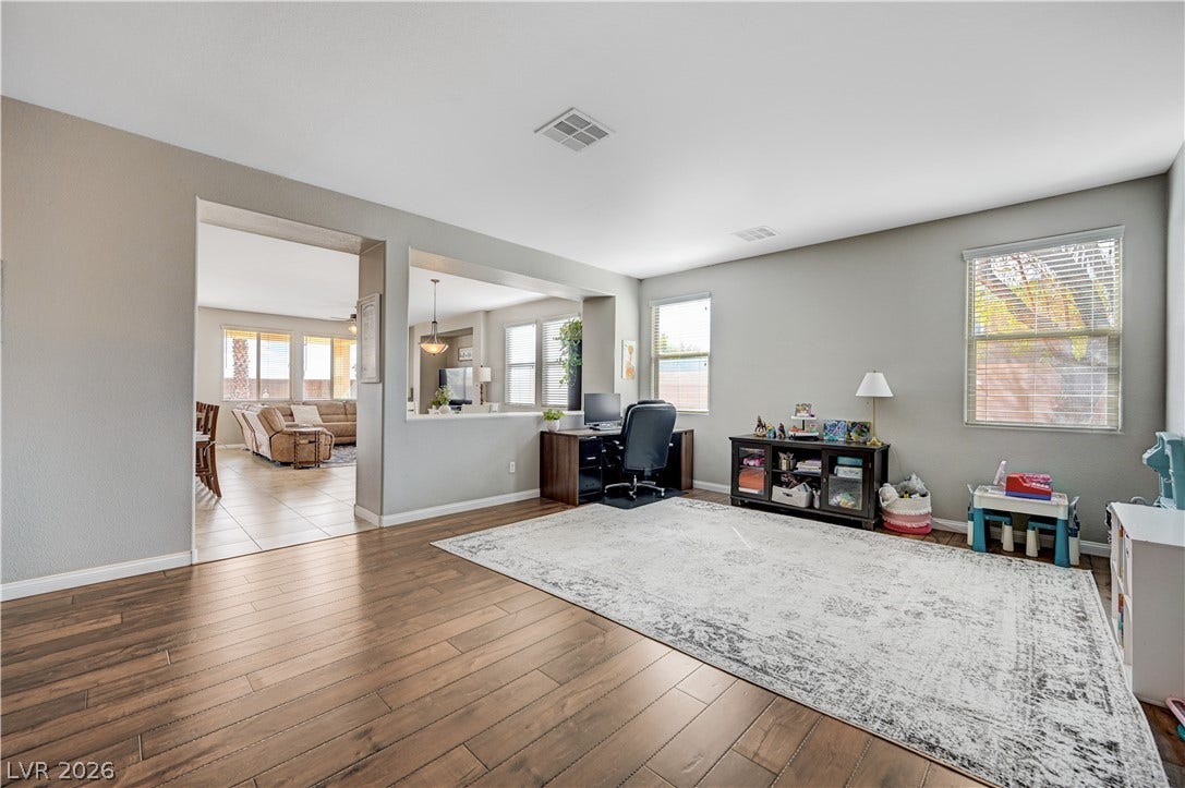Rich wood-look flooring and clean architectural cutouts define this versatile living space.