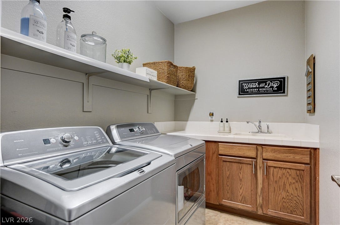 A functional workspace includes built-in cabinetry, an integrated utility sink, and sturdy overhead shelving.