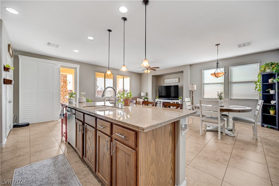 An open-concept layout connects the kitchen, dining, and living areas seamlessly over tiled flooring.