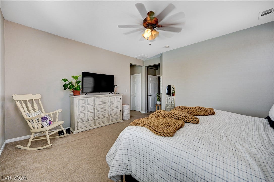 Soft carpeting pairs with neutral walls in this restful sleeping space.
